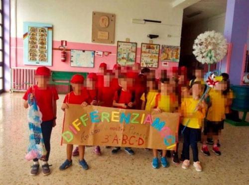 Alunni della scuola elementare Don Bosco che mostrano un cartellone con scritta “differenziamoci”, in riferimento alla necessità di fare la raccolta differenziata.